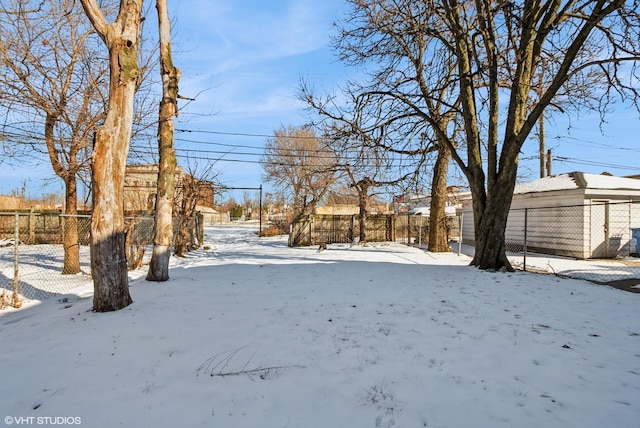 snowy yard featuring fence