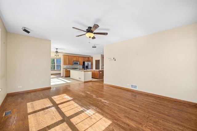 11253 Victoria Ln, Huntley, IL 60142 - unfurnished living room with light wood-type flooring, visible vents, ceiling fan, and baseboards