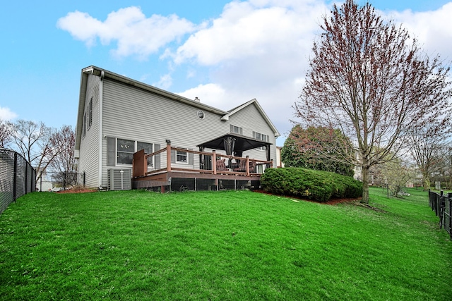 back of house featuring a lawn, a deck, and a fenced backyard