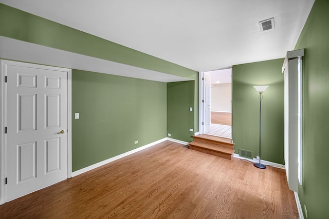 interior space featuring baseboards, visible vents, and wood finished floors