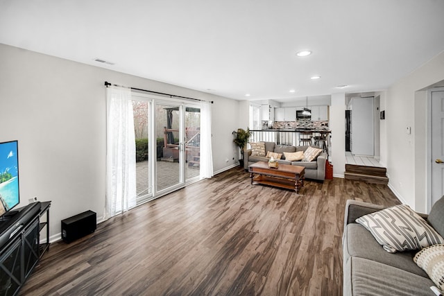 living area with dark wood finished floors, recessed lighting, and baseboards