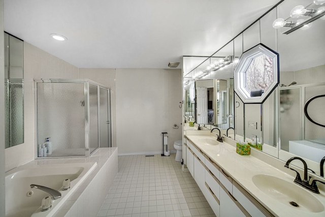 bathroom with a jetted tub, a shower stall, toilet, and a sink