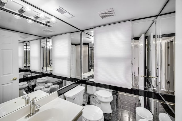 bathroom featuring visible vents, toilet, and vanity