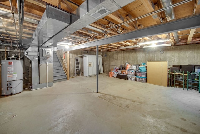 unfinished basement with water heater, visible vents, heating unit, and stairway
