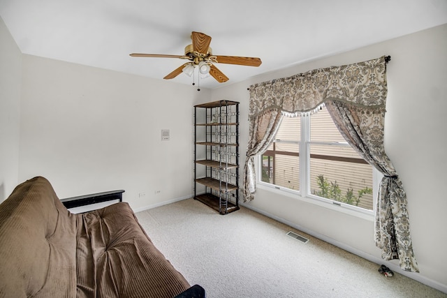 unfurnished living room featuring baseboards, visible vents, a ceiling fan, and carpet