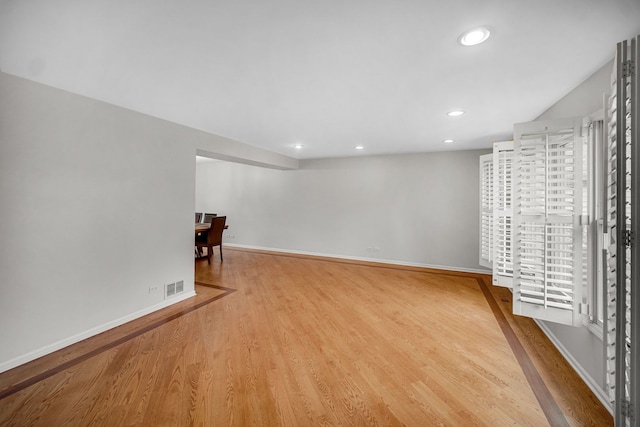 empty room with recessed lighting, visible vents, wood finished floors, and baseboards