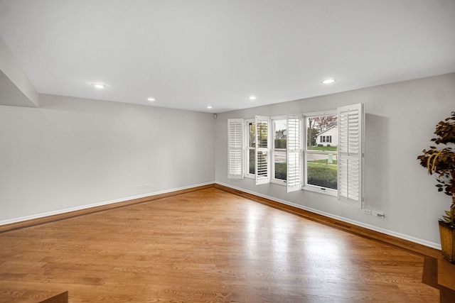 unfurnished living room with recessed lighting, visible vents, wood finished floors, and baseboards