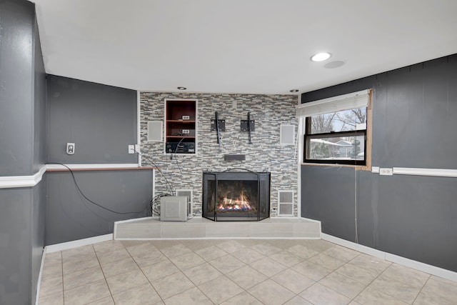 unfurnished living room with tile patterned floors, recessed lighting, and a tile fireplace