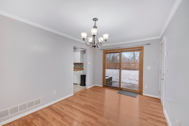 unfurnished dining area with ornamental molding, light wood finished floors, an inviting chandelier, and visible vents