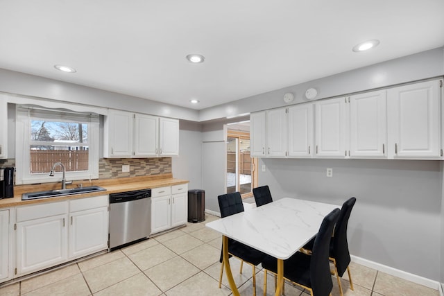 kitchen with light tile patterned floors, stainless steel dishwasher, decorative backsplash, and a sink
