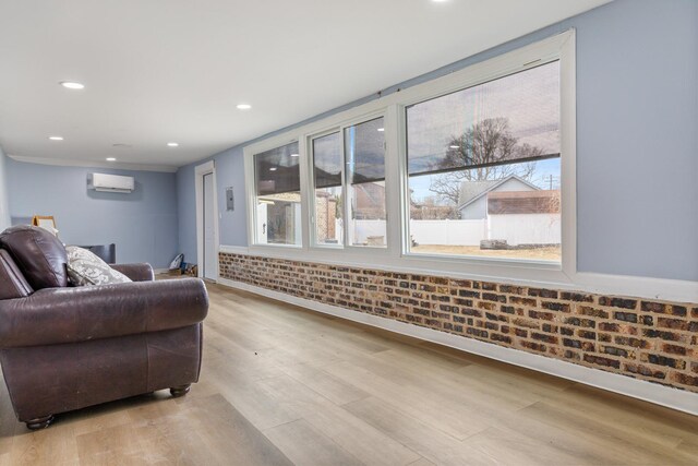 living area featuring baseboards, healthy amount of natural light, light wood finished floors, and recessed lighting