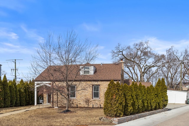 view of side of property featuring brick siding, a chimney, and a shingled roof
