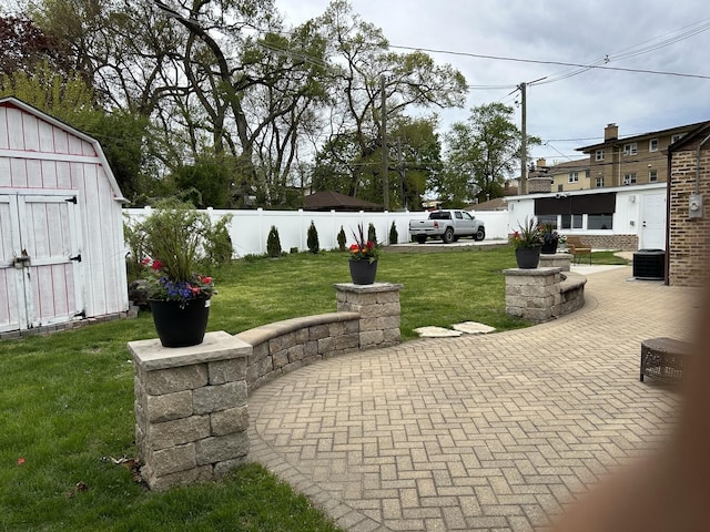 view of yard with a patio area, a storage shed, central AC, and an outdoor structure