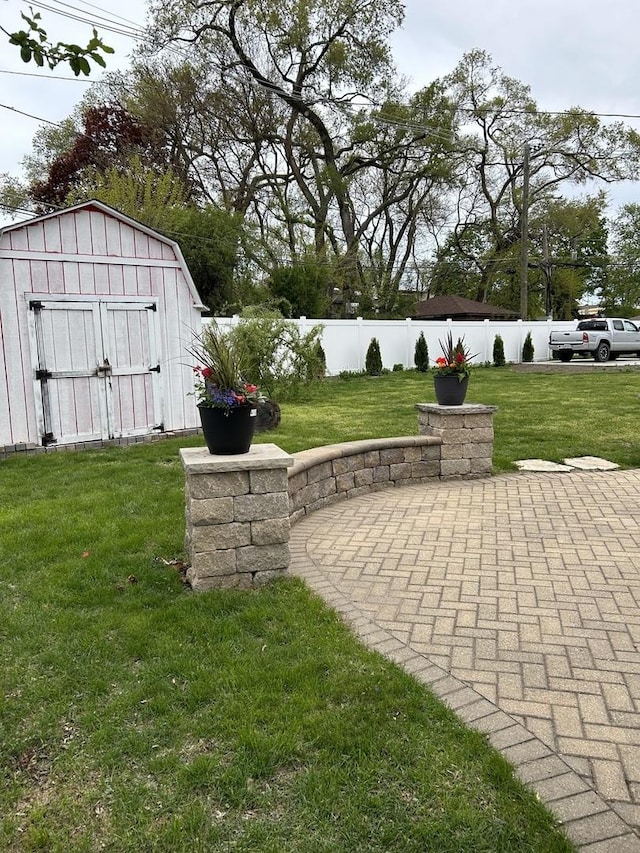 view of yard featuring a storage shed, a patio, and an outdoor structure