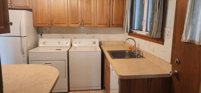 laundry room with separate washer and dryer and a sink