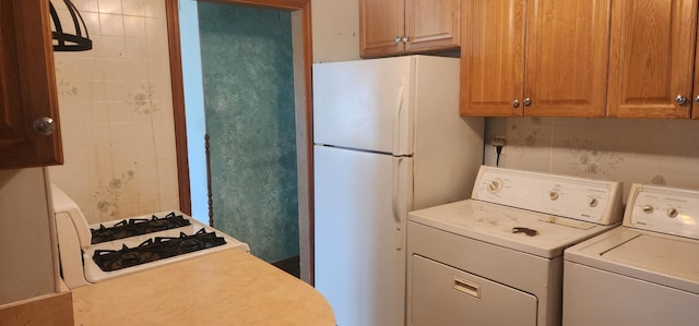 clothes washing area with washing machine and clothes dryer and laundry area