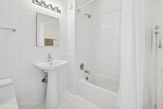 bathroom featuring tile walls, shower / bathtub combination with curtain, toilet, and tile patterned floors