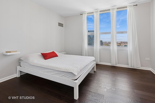 bedroom with dark wood-style flooring and baseboards