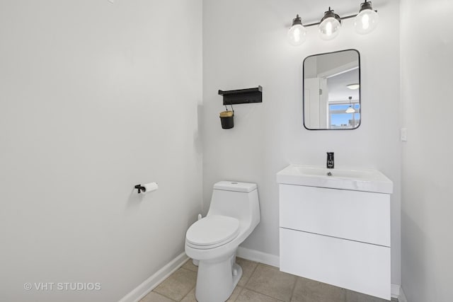 bathroom with baseboards, toilet, tile patterned flooring, and vanity