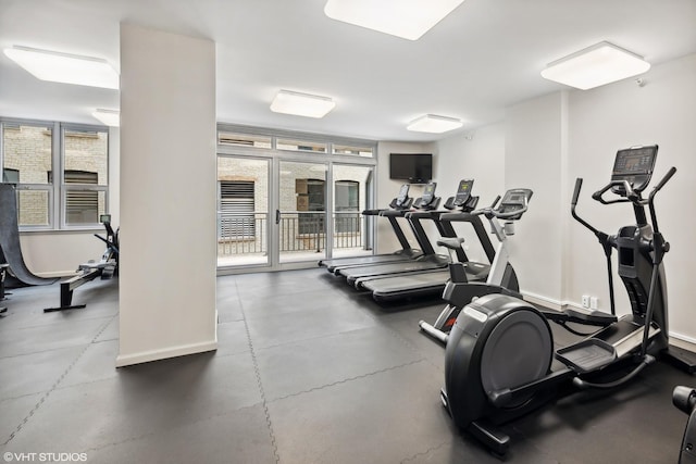 exercise room with baseboards and floor to ceiling windows
