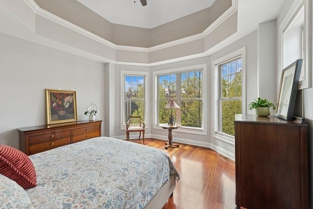 bedroom with baseboards, ceiling fan, and wood finished floors