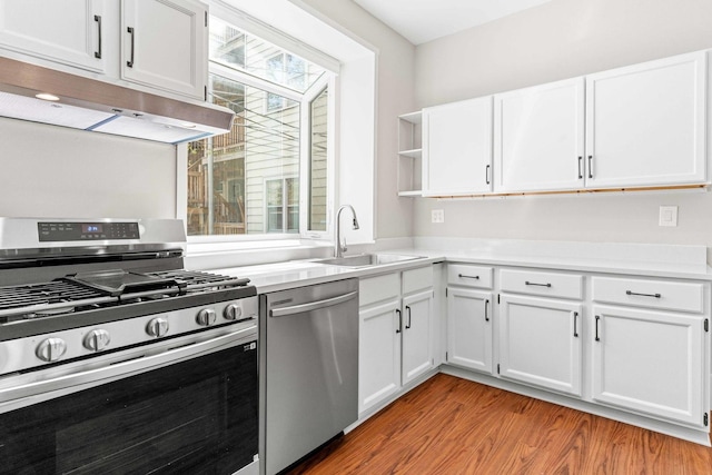 kitchen with open shelves, a sink, light wood-style floors, stainless steel appliances, and under cabinet range hood