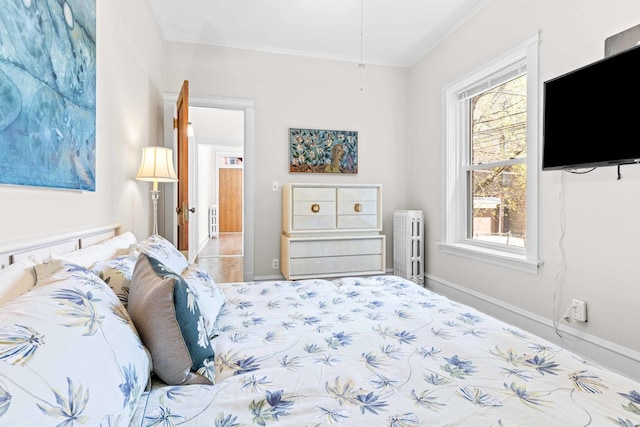 bedroom featuring baseboards, ornamental molding, and radiator heating unit