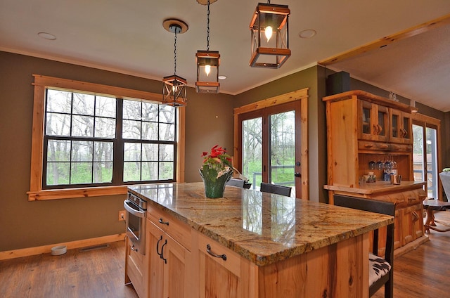 kitchen featuring oven, plenty of natural light, baseboards, and a center island