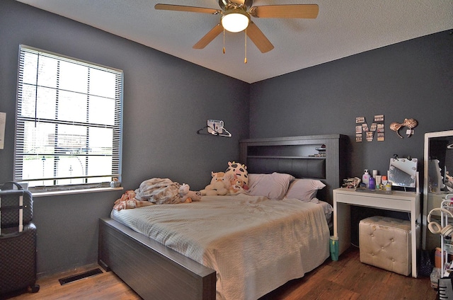 bedroom featuring visible vents, ceiling fan, and wood finished floors