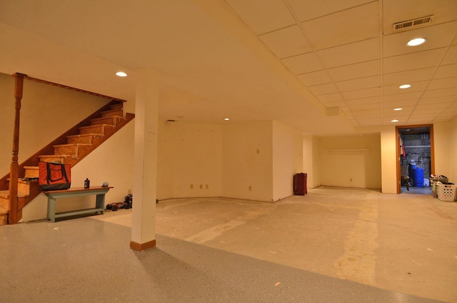 finished basement featuring recessed lighting, visible vents, and stairway