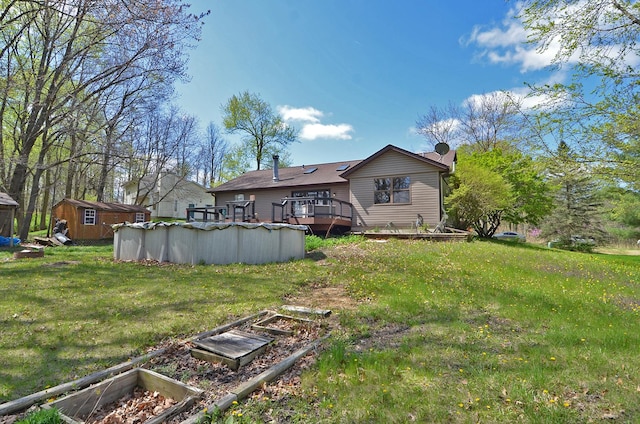 back of property with a covered pool, an outdoor structure, a yard, a storage shed, and a wooden deck