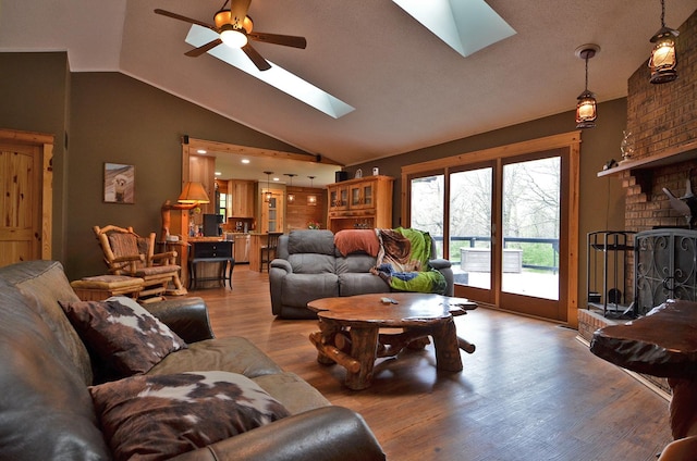 living area with ceiling fan, light wood-style floors, and lofted ceiling with skylight