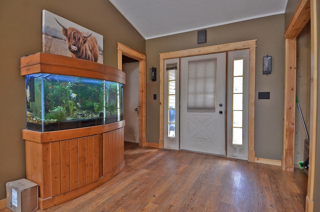 entrance foyer featuring baseboards, visible vents, wood finished floors, and ornamental molding