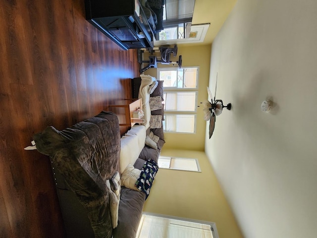 living room featuring wooden walls and visible vents