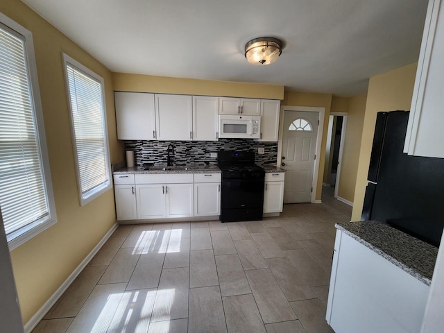 kitchen with black appliances, backsplash, light stone counters, baseboards, and white cabinetry