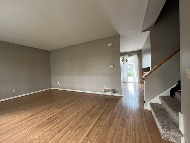 201 Meadows Rd S, Bourbonnais, IL 60914 - unfurnished room with wood finished floors, a chandelier, stairs, and baseboards
