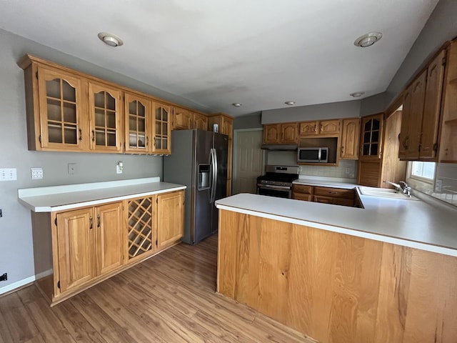 201 Meadows Rd S, Bourbonnais, IL 60914 - kitchen with appliances with stainless steel finishes, light wood-type flooring, a sink, light countertops, and glass insert cabinets