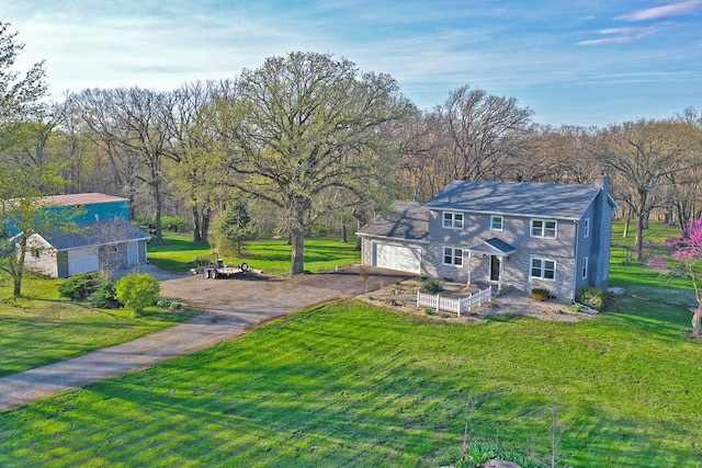 exterior space with a chimney, aphalt driveway, and a yard
