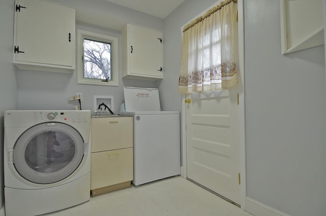 clothes washing area with washing machine and dryer and cabinet space