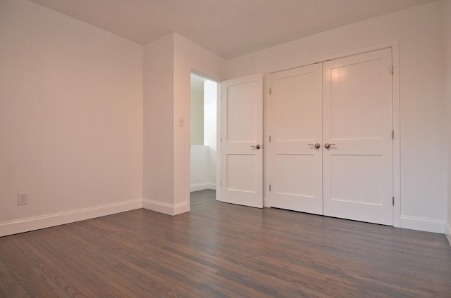 unfurnished bedroom featuring baseboards and dark wood-type flooring