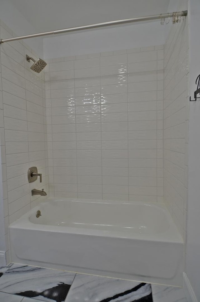full bathroom featuring baseboards,  shower combination, and marble finish floor