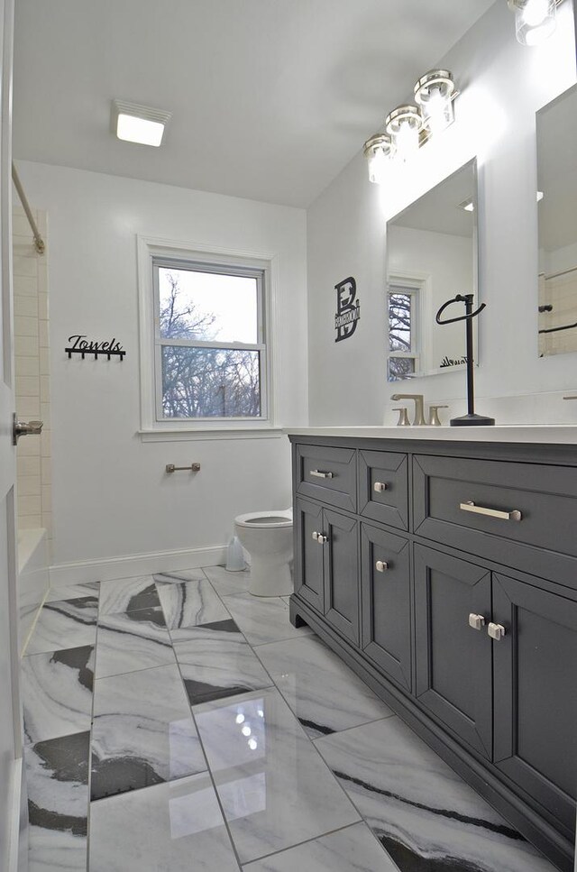 full bath with marble finish floor, toilet, shower / tub combination, vanity, and baseboards