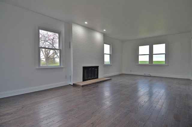 unfurnished living room with baseboards, recessed lighting, a fireplace, dark wood-style floors, and visible vents