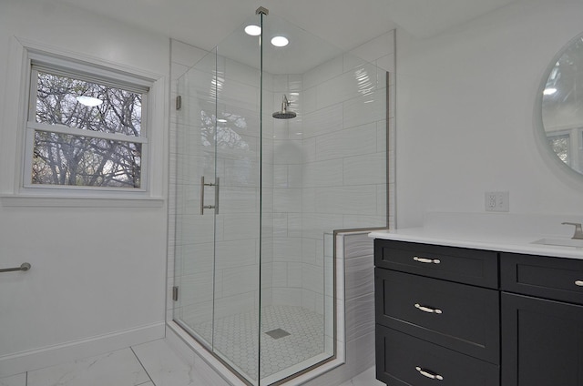 full bath with a stall shower, marble finish floor, vanity, and baseboards