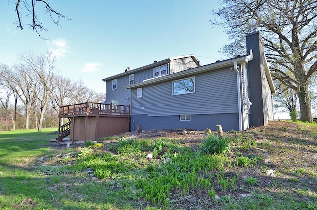 rear view of house with stairway, a chimney, a yard, and a deck