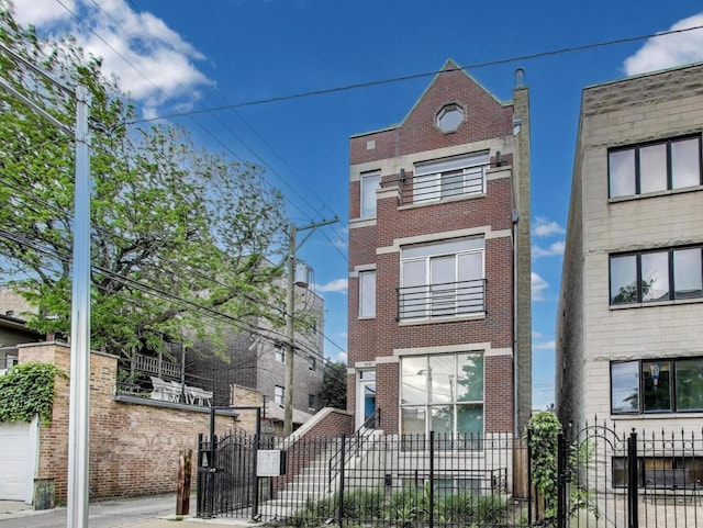 512 N Claremont Ave Unit 2, Chicago, IL 60612 - view of front of house with brick siding, a gate, and a fenced front yard
