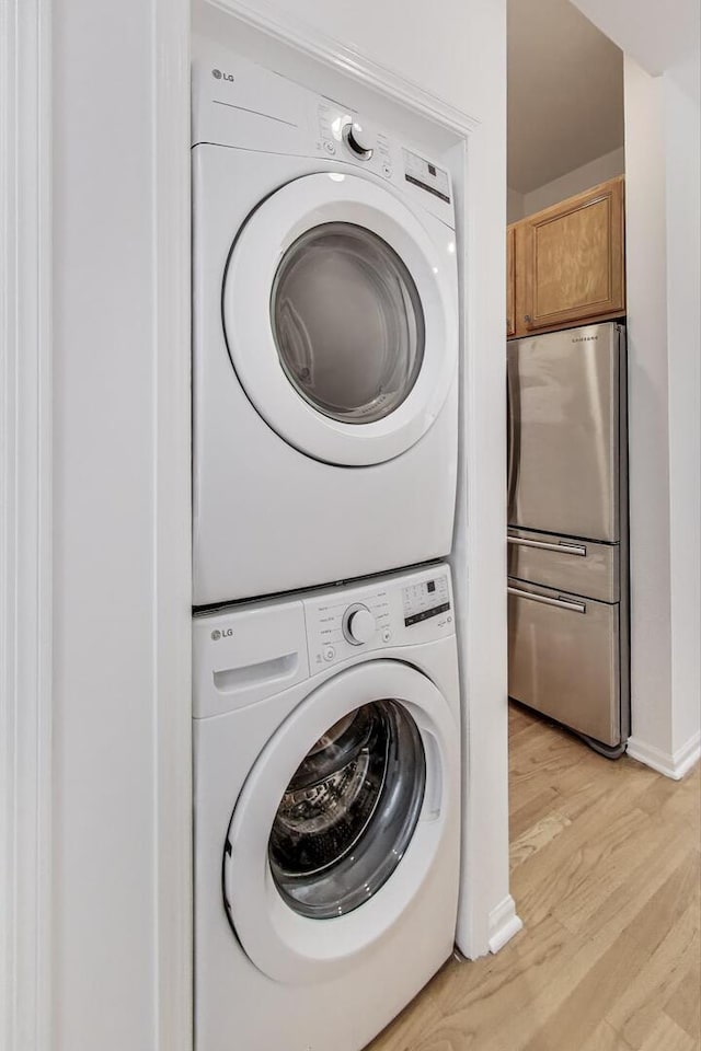 512 N Claremont Ave Unit 2, Chicago, IL 60612 - laundry room with estacked washer and dryer, light wood-style floors, and baseboards