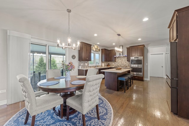 dining room with recessed lighting, wood finished floors, and a chandelier