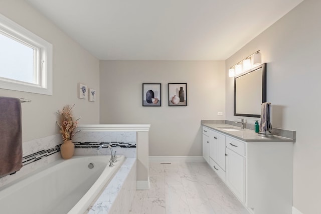full bath featuring a bath, baseboards, marble finish floor, and vanity