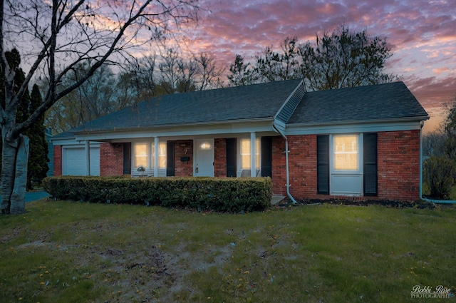 single story home with brick siding, roof with shingles, and a front lawn